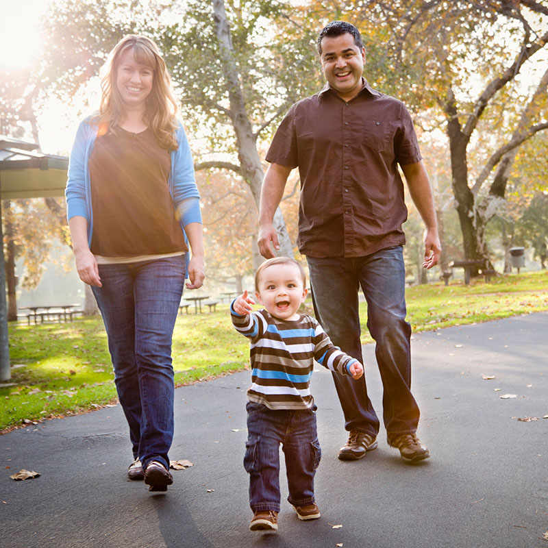 Happy family walking down the park street