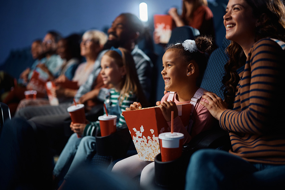 Woman and kids watching a movie in a theater