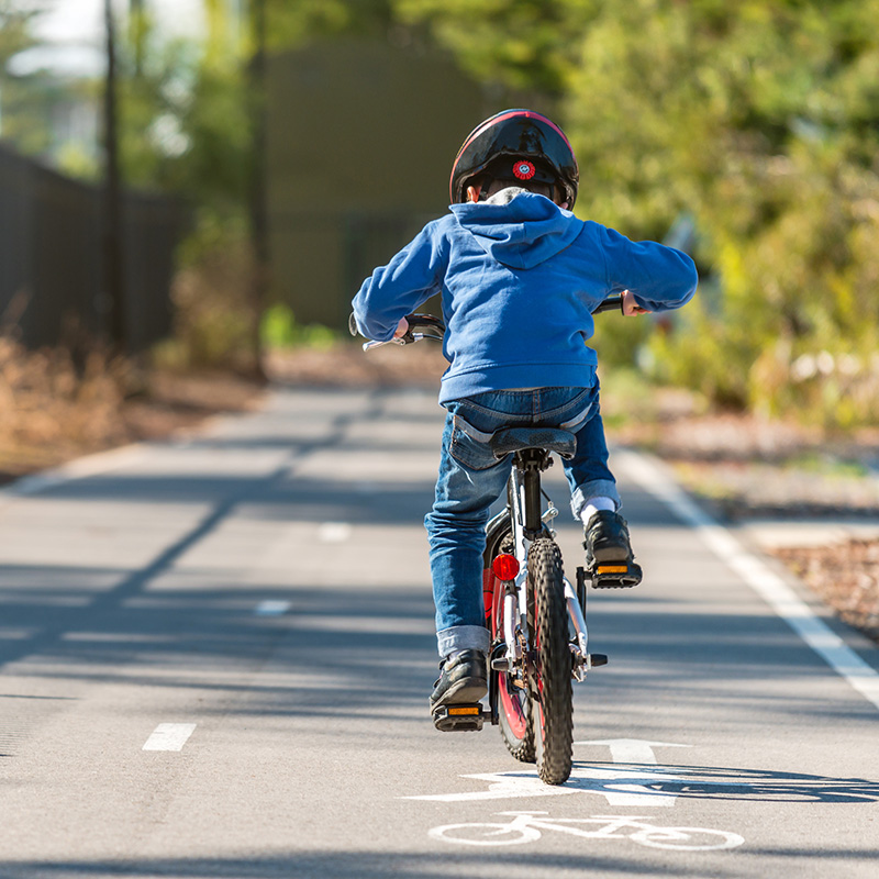 Kid riding his bicycle on bike lane